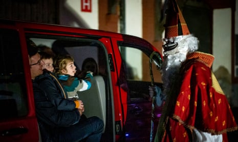 Members of the Cirk La Putyka troupe entertain families driving through with their cars on the eve of St Nicholas Day in Prague.