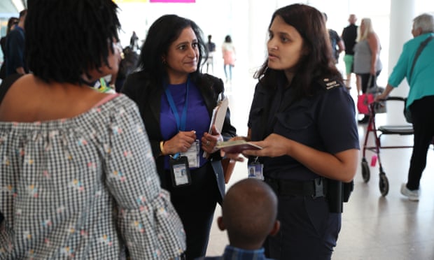 A Border Force official speaks to passengers following their arrival at Heathrow airport