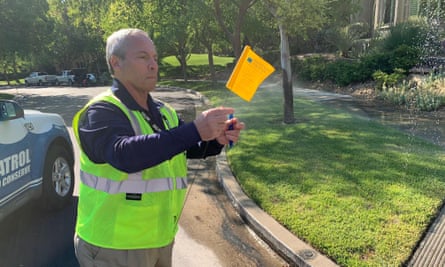 Perry Kaye, a water waste investigator in Las Vegas, Nevada, issues a yellow warning flag because of a faulty sprinkler.