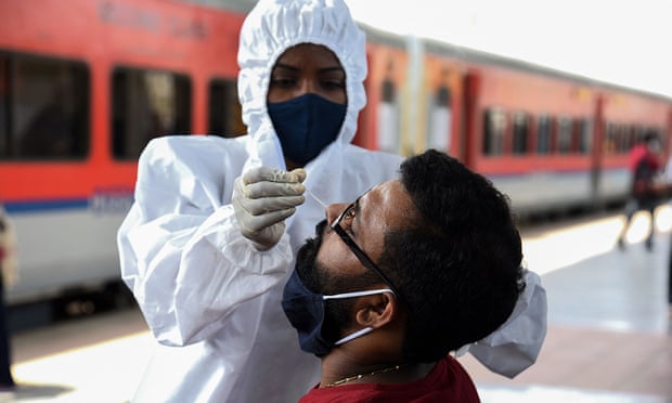 A train passenger is tested for Covid after arriving in Mumbai.