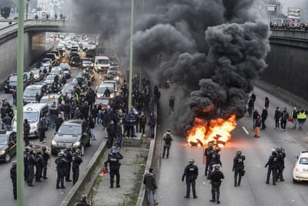 Striking French taxi drivers try to march down a major bypass during a day of protests against services such as Uber in January 2016