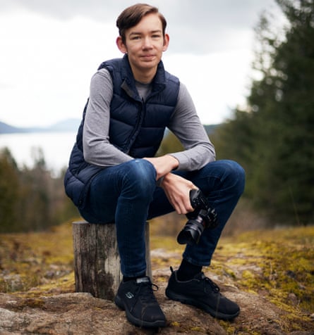 Young climate activist Dylan D’Haeze, 16, photographed in Washington state, US, sitting on a rock, holding a camera