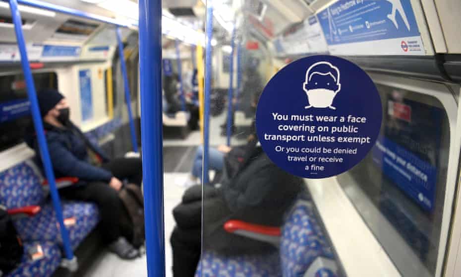 A sign asking face coverings to be worn on an underground train in London