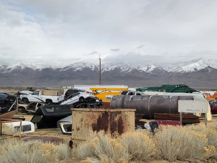 pile of cars and other vehicles, with mountains in distance
