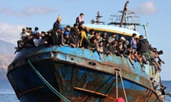 Migrants sit onboard a fishing boat at the port of Paleochora, following a rescue operation off the island of Crete, Greece