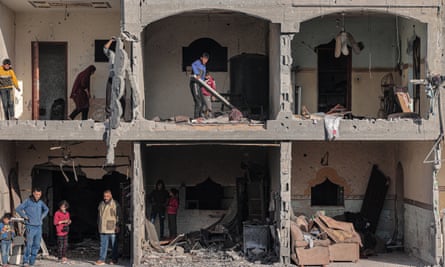 Palestinian men check the debris at a building on 22 February following overnight Israeli air strikes in Rafah refugee camp.