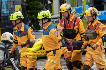Rescue workers carry a participant on a stretcher during a civil defence drill in Taipei