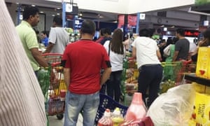 People buying food staples at a supermarket in Doha, Qatar.