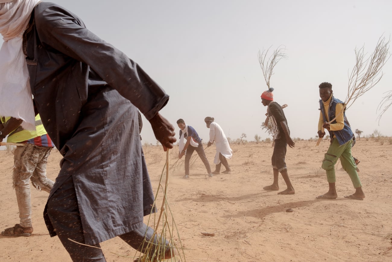 The men walk in a diagonal formation during their firefighting practice session, whooping and yelling