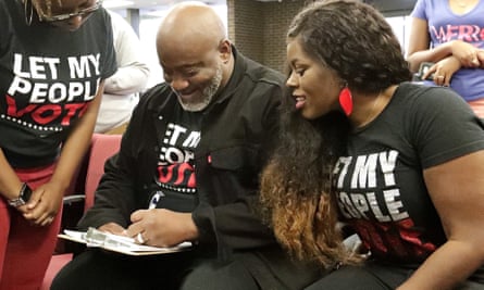 In this photo, former felon Desmond Meade and president of the Florida Rights Restoration Coalition, left, fills out a voter registration