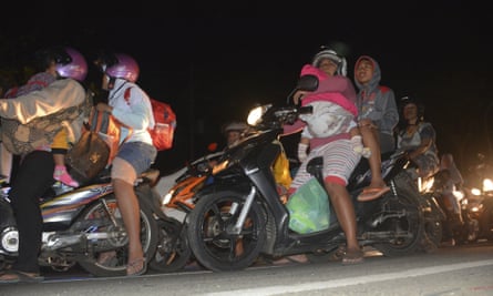 People try to reach higher ground amid fears of tsunami, following an earthquake on the island of Java.