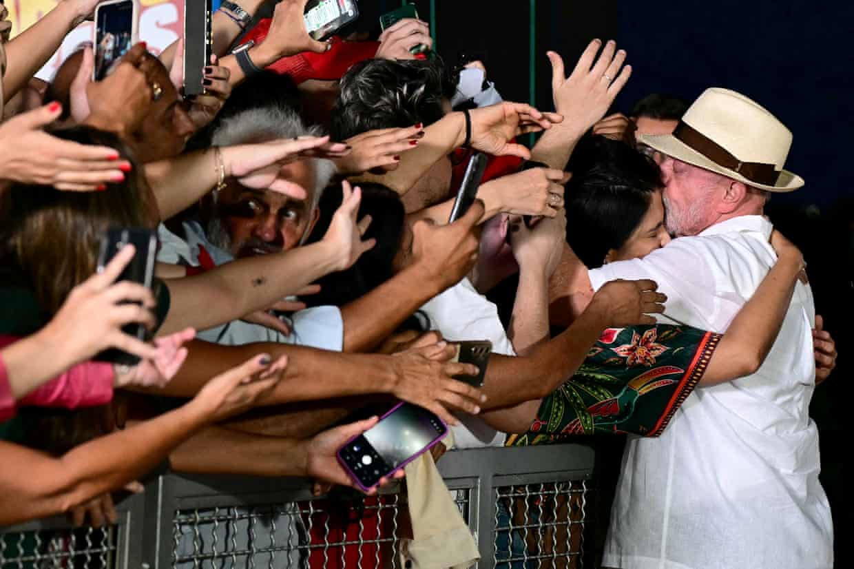 Brazil’s president, Luiz Inacio Lula da Silva, hugs a woman who is part of a crowd of supporters.