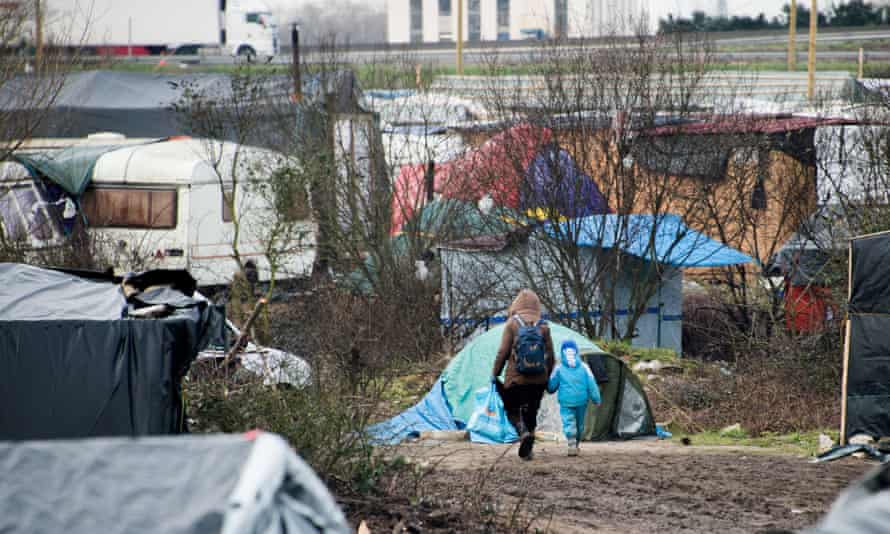 A woman walks with her child in the Jungle migrants and refugee camp in Calais, in 2016, where Onjali got the idea to for her novel The Boy at the Back of the Class.