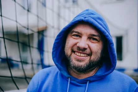 Petro smiles for the camera wearing a bright blue hoodie with the hood up