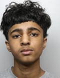 he has black wavy hair cut short at the front and sides but longer on top and wears a grey T-shirt.