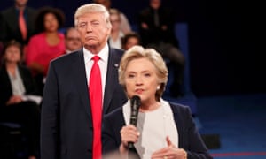 Donald Trump lurks behind Hillary Clinton as she answers a question from the audience.