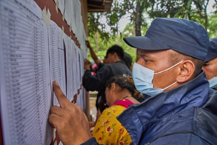 People search lists for the names of relatives on wall in Nepal’s Nuwakot district.