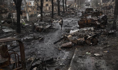 A woman walks amid destroyed Russian tanks in Bucha, in the outskirts of Kyiv, Ukraine,on Sunday 3 April.