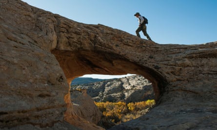 A man walks over a natural bridge at Butler Wash in Bears Ears national monument near Blanding, Utah on 27 October 2017.
