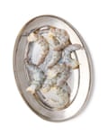 A plate of peeled, raw prawns, salted