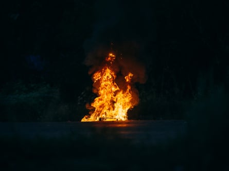 Flames rise from a drone at night.