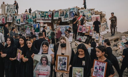 Yazidis women hold pictures of their missing relatives on the eve of the tenth anniversary of the genocide in 2024