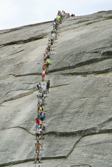 long line of people hiking up a steep cliff