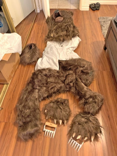 A bear costume on a wood floor.