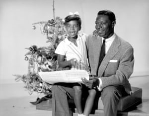 Singer Nat ‘King’ Cole and his daughter Natalie pose for a portrait session in front of a Christmas tree in 1955