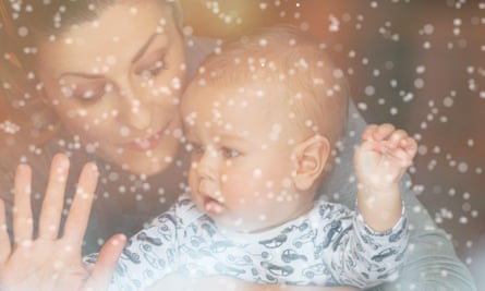 A woman and a child behind a glass window in snowy weather.