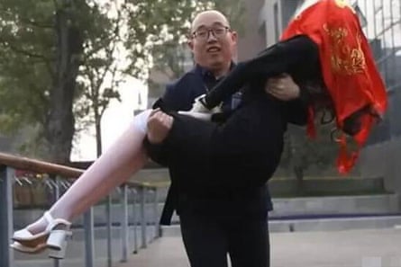 Zheng Jiajia carried his robot wife – her head covered in red cloth in accordance with local tradition.