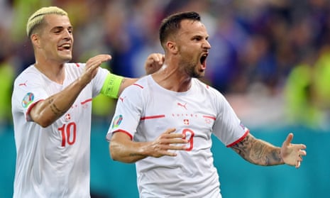 Haris Seferovic celebrates after scoring the first of his two goals for Switzerland in the win over France, with the captain, Granit Xhaka, in pursuit.