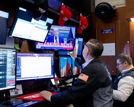 A trader looks at a screen showing Donald Trump.