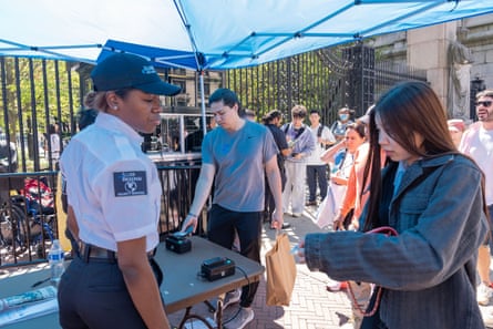 woman shows ID to security guard