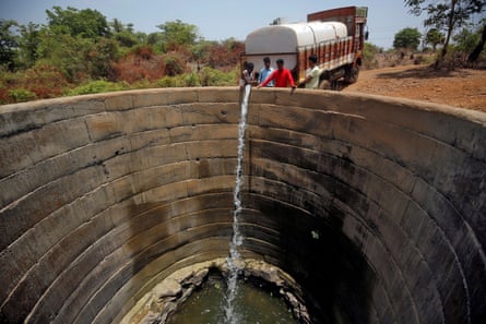 A dried-up well is refilled with water from a water tanker in Thane district in the western state of Maharashtra