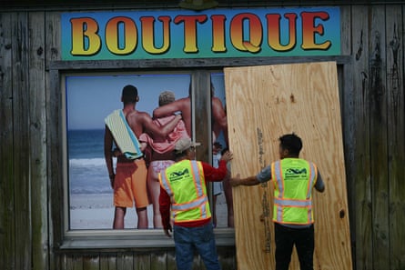 workers board up a store