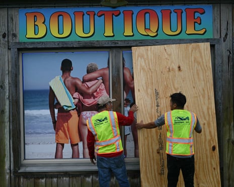 Workers board up a storefront in Pensacola Beach, Florida.