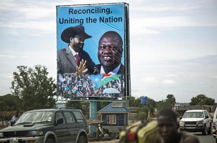 A billboard showing two smiling men on a busy road. It reads ‘Reconciling, Uniting the Nation’