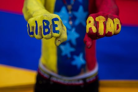 An anti-government protester with the word ‘freedom’ painted on his fists in the colours of the Venezuela flag.