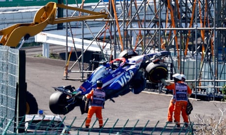 The car of Daniel Ricciardo is recovered by marshals after crashing at the start of the Japanese GP.