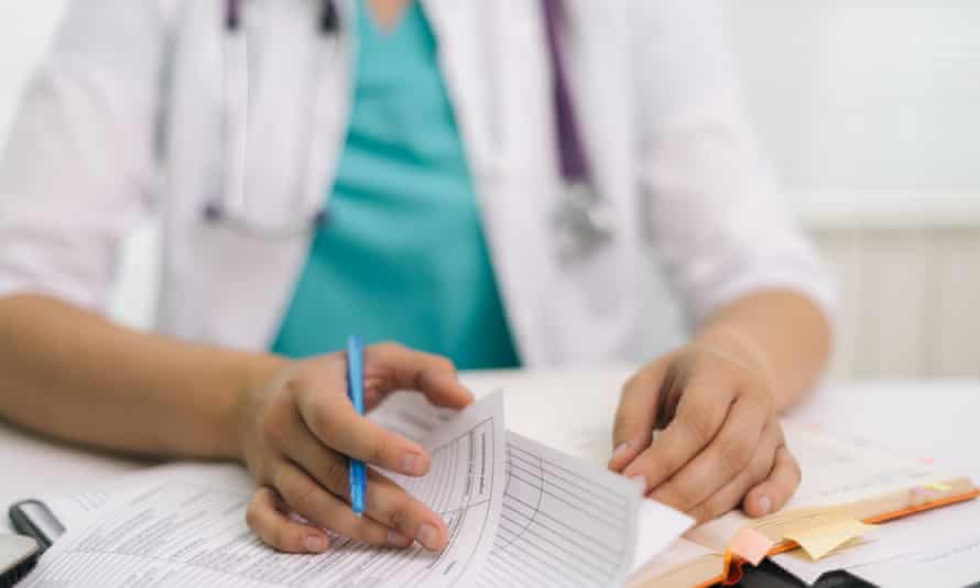 Close-up hands of woman doctor writing a prescription