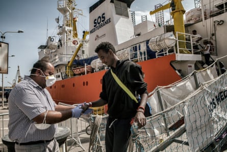 Authorities check the migrants as they disembark from the Aquarius