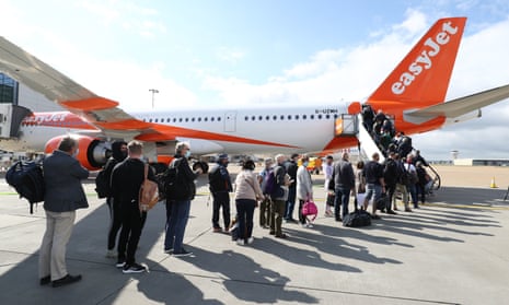 Passengers prepare to board an easyJet flight to Faro, Portugal, at Gatwick airport