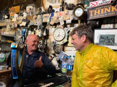 Runner in hi vis talking in pub with barman who’s giving him the thumbs up