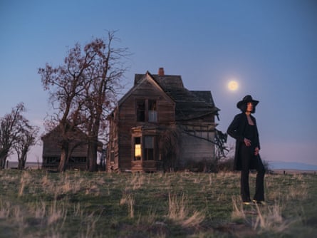 Lawrence Rothman standing in front of a wooden house in the moonlight