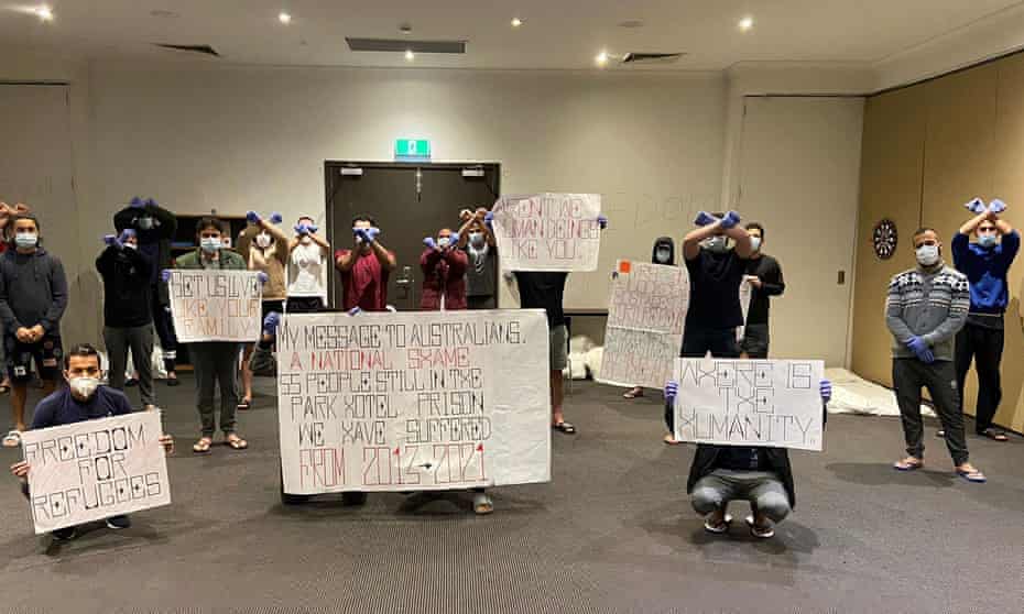 Asylum seekers and refugees protest their ongoing detention at Melbourne's Park hotel on Monday night. Up to six refugees at the hotel have tested positive to Covid. September figures show that double-dose vaccination rates in hotels the government commandeered and designated as detention centres was just 13%.
