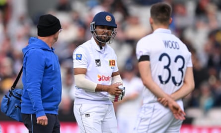 Dinesh Chandimal leaves the field after being hit on the hand by a delivery from Mark Wood.