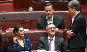 Labor’s leader in the Senate, Penny Wong, talks to Greens senators during the debate on the $144bn tax cuts package.