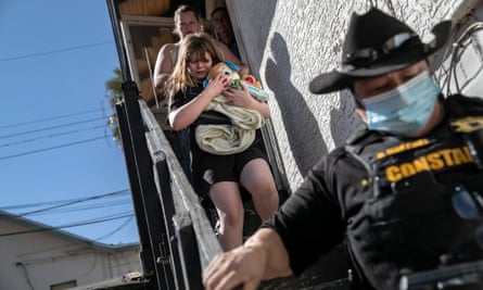 A county constable escorts a family out of their home after serving an eviction notice in Phoenix, Arizona.