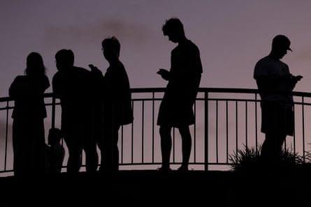 Kids on phones in silhouette